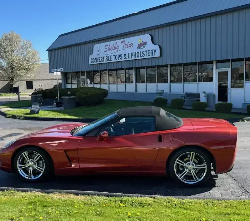 Red Corvette with newly fitted black convertible top.