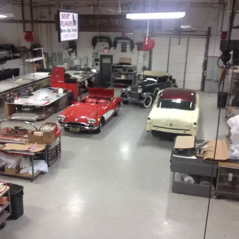 A red convertible mid-restoration on the Shelby Trim shop floor.