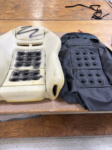 Original performance seat foam beside the new black leather cover patterned and sewn to fit it.