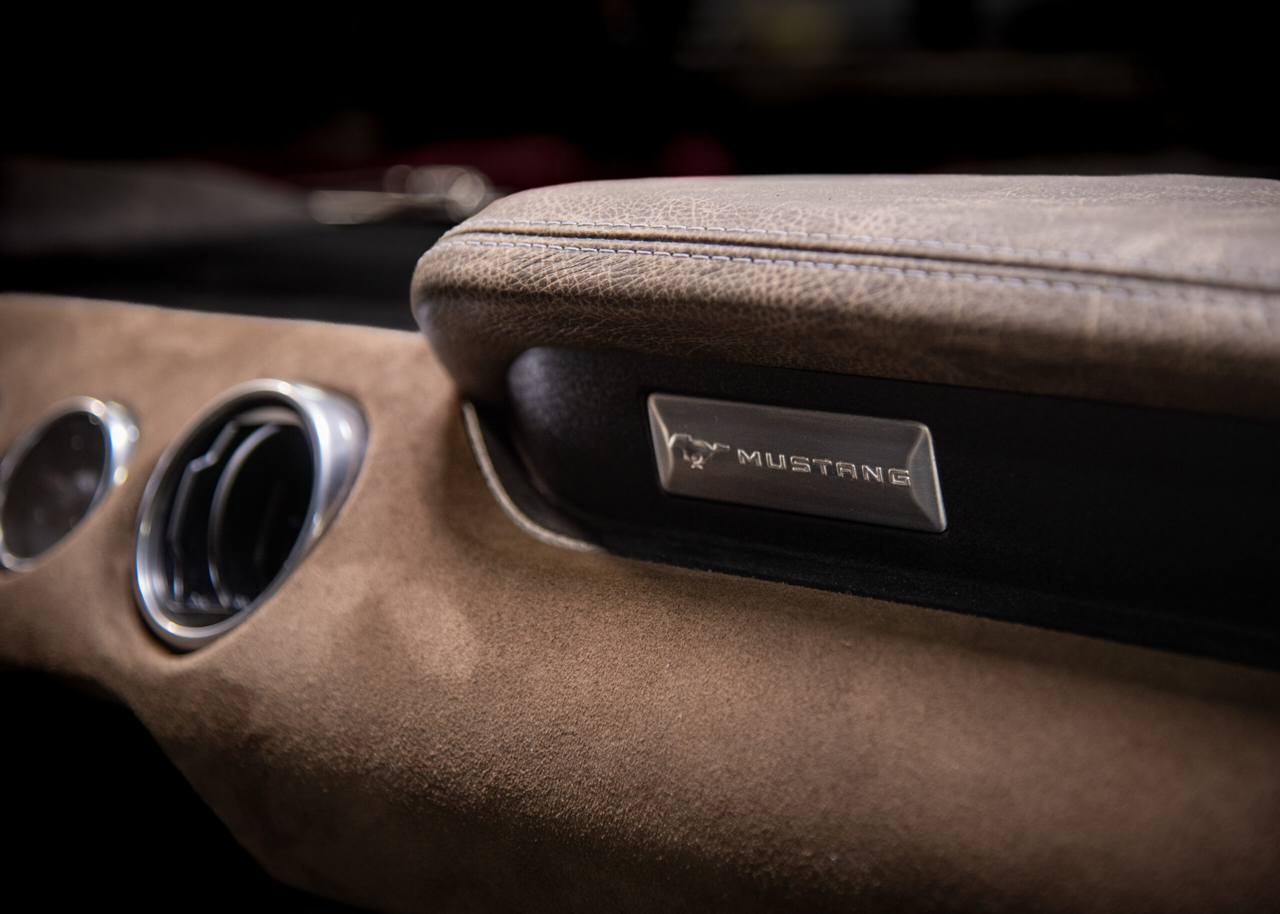 Suede-covered dashboard with polished vents and a leather-wrapped glove box pad in a custom Shelby Mustang.
